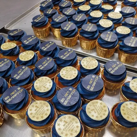 Синие капкейки с логотипом компании на шоколадных медалях
